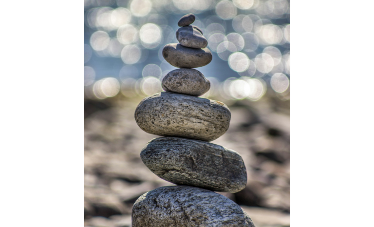 Zen-Stein-Stapel am Strand vor verschwommenem Hintergrund