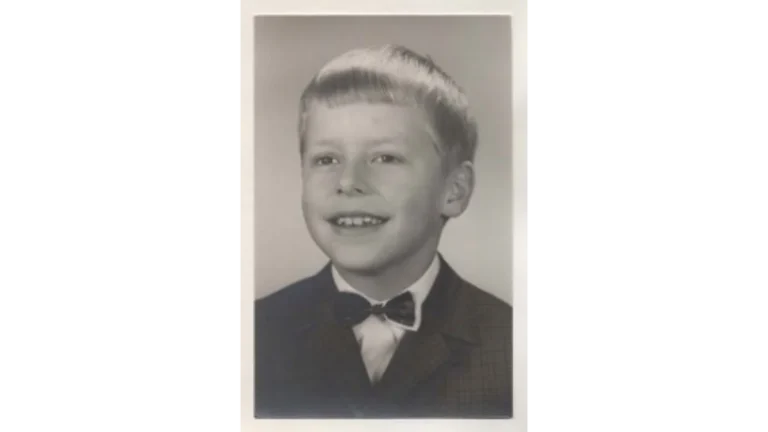 Ein historisches Schwarz-Weiß-Porträt des jungen Klaas Theo, der freundlich mit einer Fliege in die Kamera lächelt; sein früher Tod bildet den Kern des Kindheitstraumas des Autors.