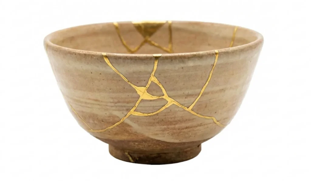 Eine mit Gold reparierte Kintsugi-Schale schwebt vor weißem Hintergrund, als Symbol für Heilung, Akzeptanz und neue Perspektiven im Zen-Kurs für Long Covid Betroffene