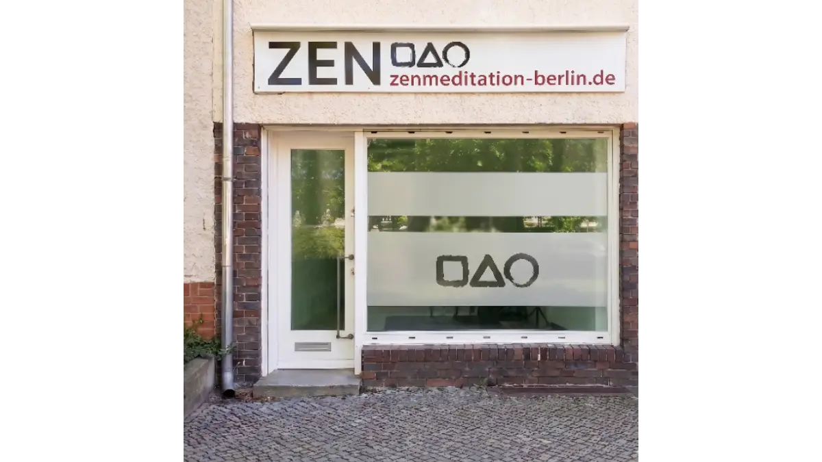 Der ruhige und einladende Eingang des Zen-Meditationszentrums Berlin mit dem Logo auf der matten Sichtschutzfolie.